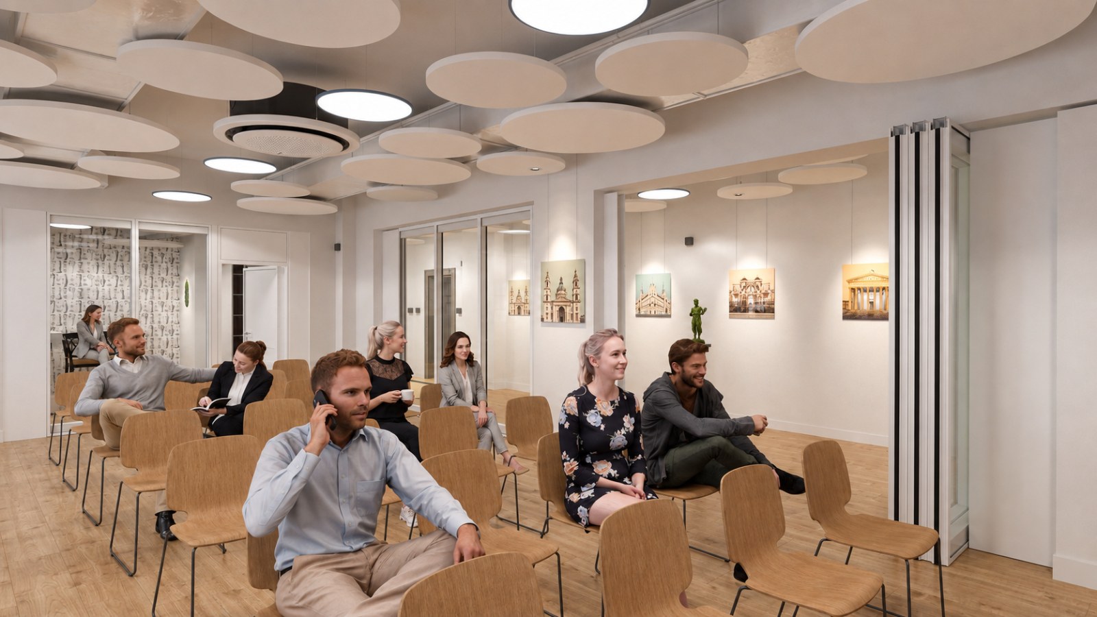 Lecture space with rows of chairs, a dense field of circular acoustic panels overhead, prints of Budapest buildings on the right-hand wall and a folding wall at the far end