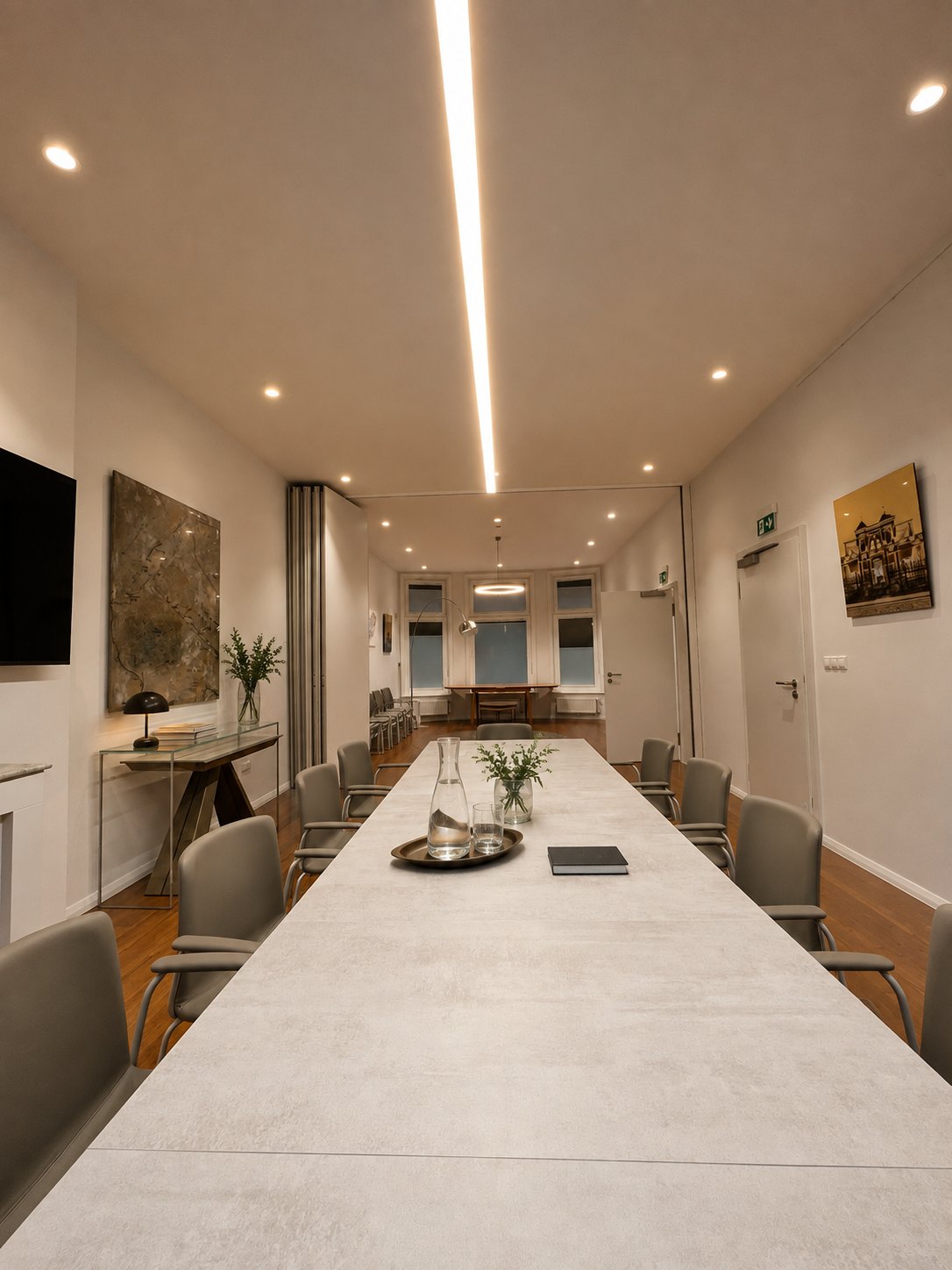 The long meeting table seen towards the open folding partition, the view carrying through into the adjoining room