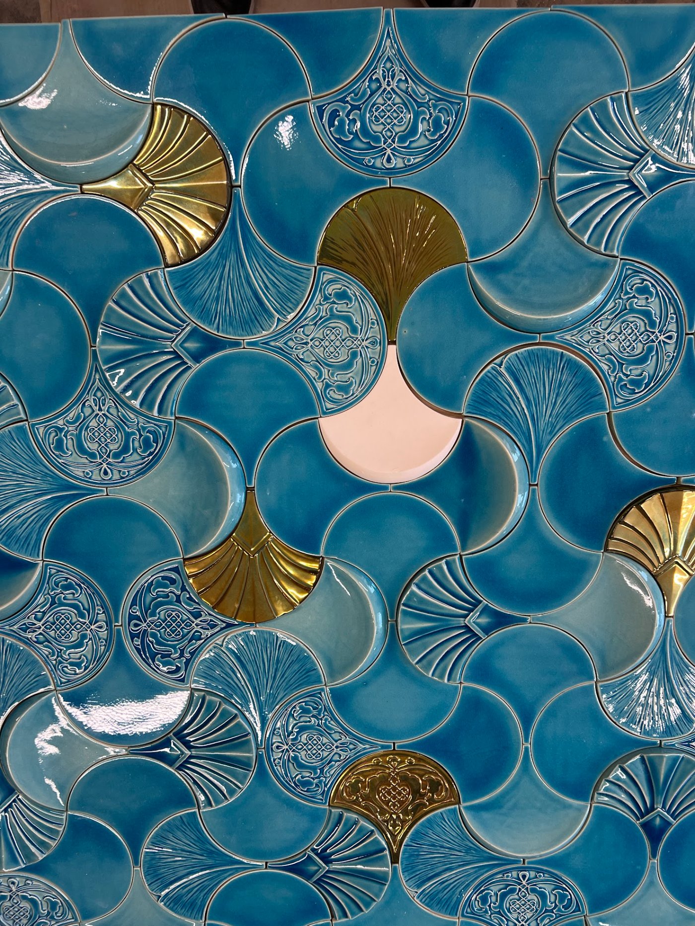 A teal Just Play tile surface close up, with gold eosin and pale pink elements in the pattern
